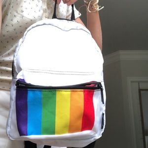 Mini Polaroid style backpack, white, black details, rainbow on front pocket.